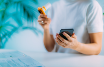 Person performing a spirometry test for Asthma or COPD while referring to their phone.